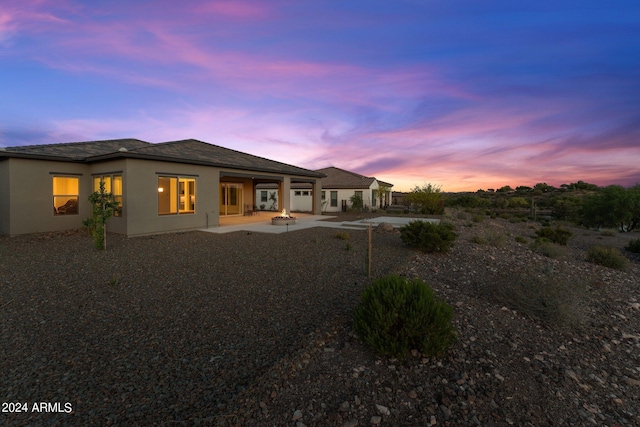 back house at dusk with a patio