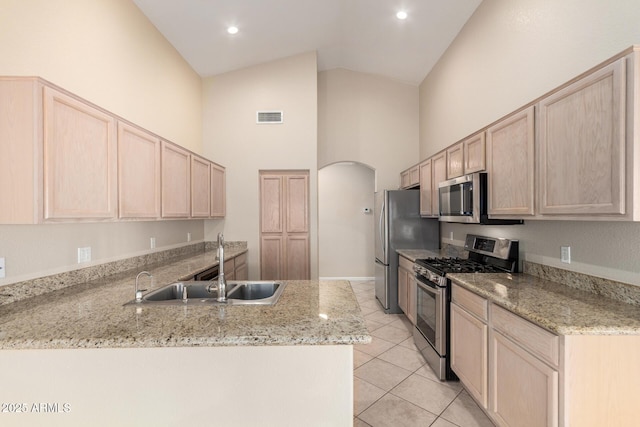 1625 E Daisy St, Casa Grande, AZ 85122 - kitchen featuring appliances with stainless steel finishes, light brown cabinetry, a sink, high vaulted ceiling, and arched walkways