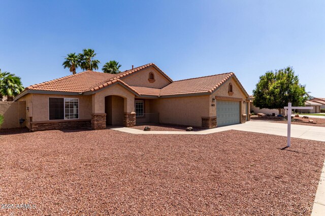 1625 E Daisy St, Casa Grande, AZ 85122 - mediterranean / spanish house with stucco siding, stone siding, driveway, and a garage