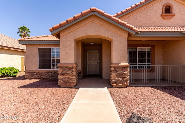 1625 E Daisy St, Casa Grande, AZ 85122 - view of exterior entry with stone siding, stucco siding, and a tile roof