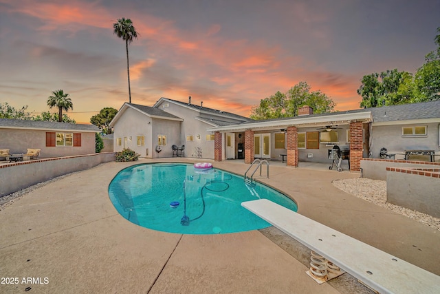 5621 N 13th St, Phoenix, AZ 85014 - pool at dusk featuring a patio, a ceiling fan, a diving board, and area for grilling