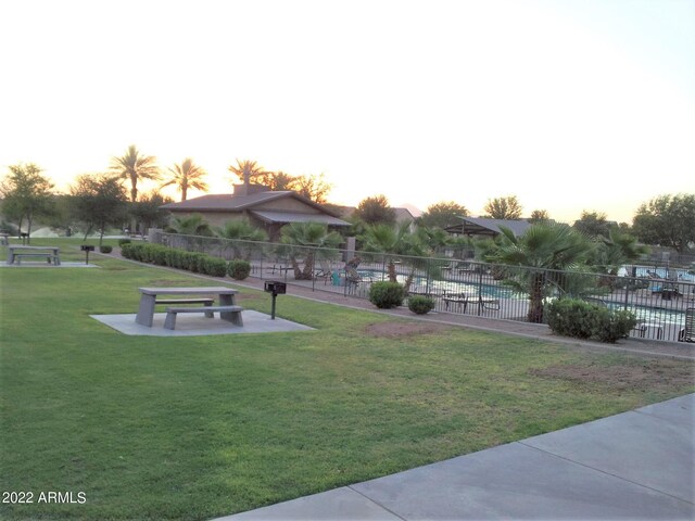 view of home's community with a pool and a lawn