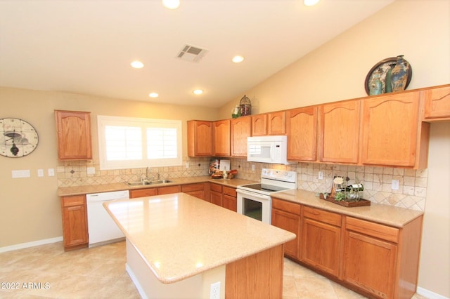 kitchen featuring a kitchen island, white appliances, sink, tasteful backsplash, and light tile floors