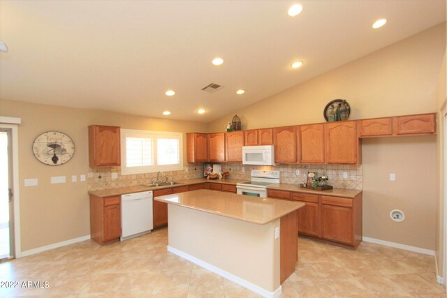 kitchen featuring white appliances, a kitchen island, backsplash, light tile floors, and lofted ceiling