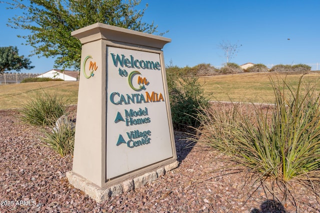 community / neighborhood sign with a lawn and a rural view