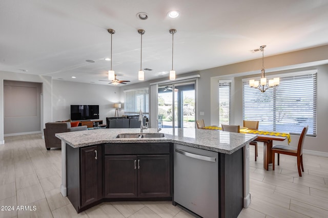 kitchen featuring light stone countertops, dishwasher, sink, an island with sink, and pendant lighting