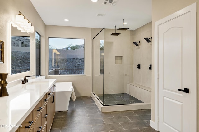full bathroom with a stall shower, vanity, a soaking tub, and visible vents