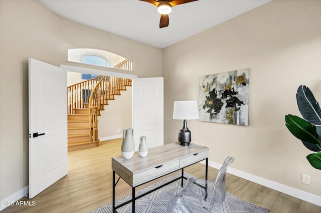office space with a ceiling fan, baseboards, and wood finished floors
