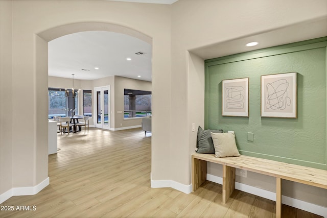 hallway with wood finished floors, visible vents, recessed lighting, arched walkways, and baseboards