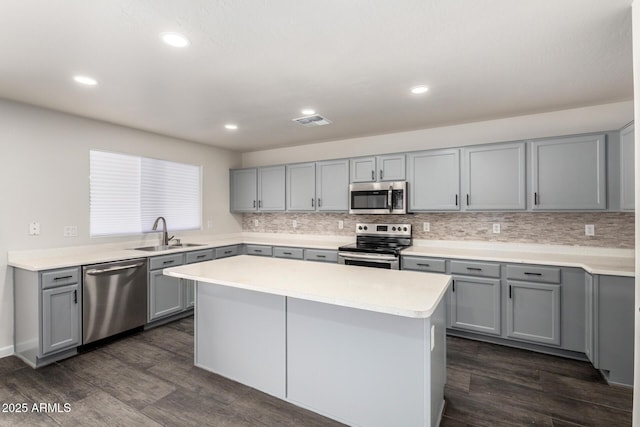 6637 W Watkins St, Phoenix, AZ 85043 - kitchen featuring stainless steel appliances, gray cabinetry, a sink, tasteful backsplash, and dark wood finished floors