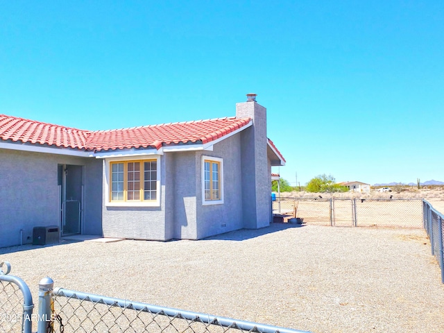 69762 Old Bell Rd, Salome, AZ 85348 - rear view of house with stucco siding, a fenced backyard, a chimney, and a tiled roof