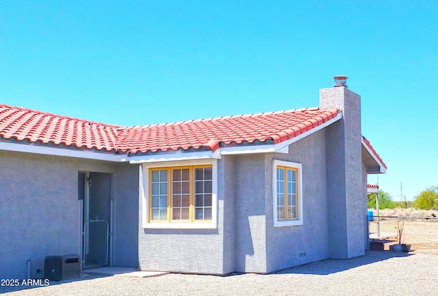 69762 Old Bell Rd, Salome, AZ 85348 - view of side of property with stucco siding, a tile roof, and a chimney