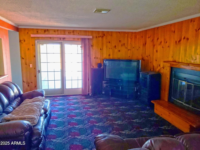 69762 Old Bell Rd, Salome, AZ 85348 - living area featuring ornamental molding, wood walls, a textured ceiling, carpet, and a glass covered fireplace