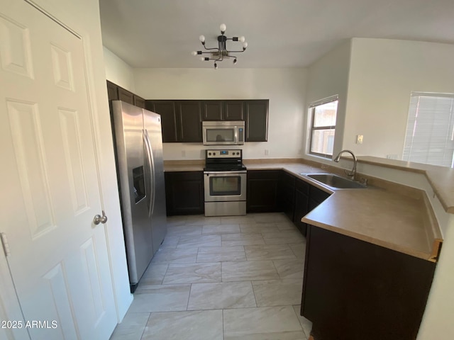 525 N Miller Rd Unit 239, Scottsdale, AZ 85257 - kitchen with stainless steel appliances, a sink, a chandelier, light marble finish flooring, and light countertops