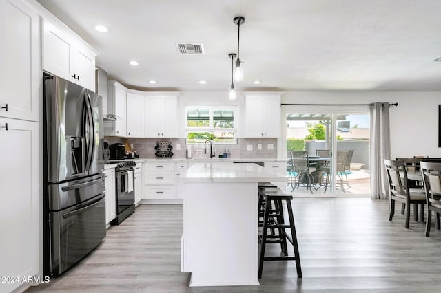 2041 E Harvard Dr, Tempe, AZ 85283 - kitchen featuring stainless steel refrigerator with ice dispenser, electric range, a kitchen breakfast bar, light wood-style flooring, and light countertops