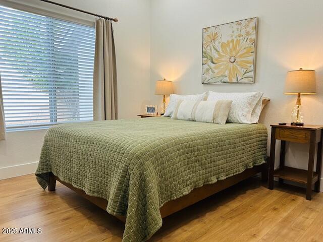 bedroom featuring wood finished floors and baseboards