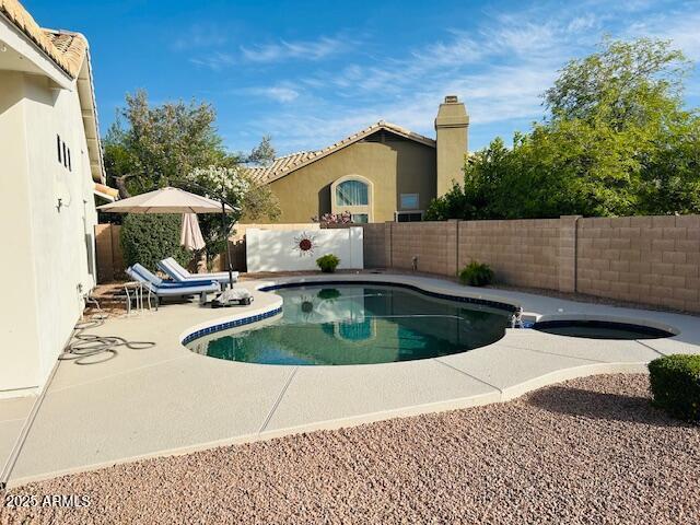 view of pool with a fenced backyard, a patio area, and a pool with connected hot tub