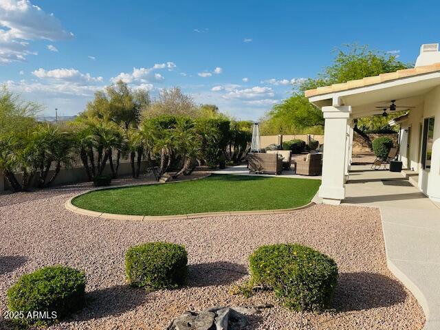 view of yard with ceiling fan, outdoor lounge area, and a patio area