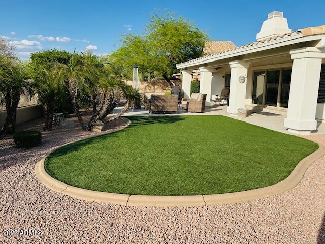 view of green lawn featuring outdoor lounge area and a patio