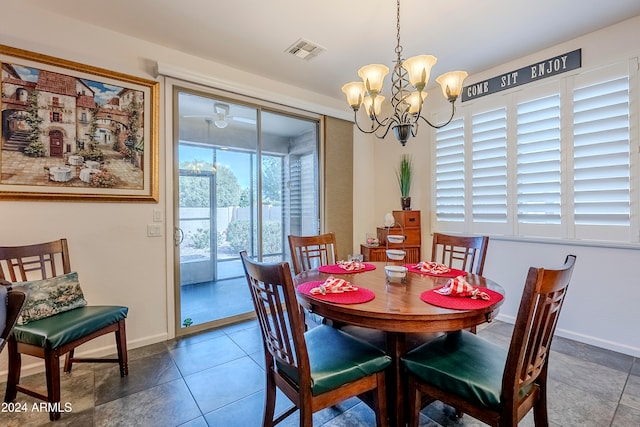 dining area with tile patterned floors and a notable chandelier