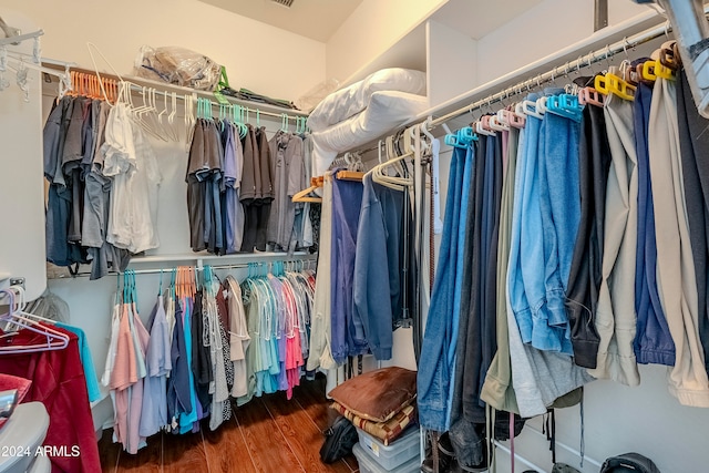 walk in closet with dark wood-type flooring