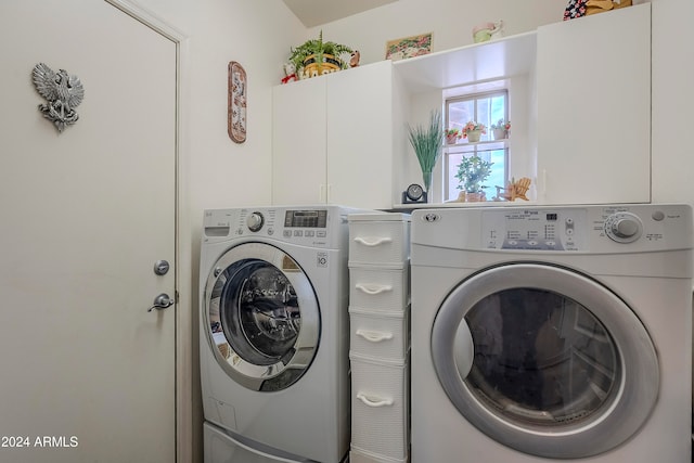 laundry room featuring washer and clothes dryer and cabinets