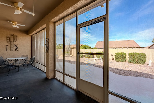 unfurnished sunroom featuring ceiling fan