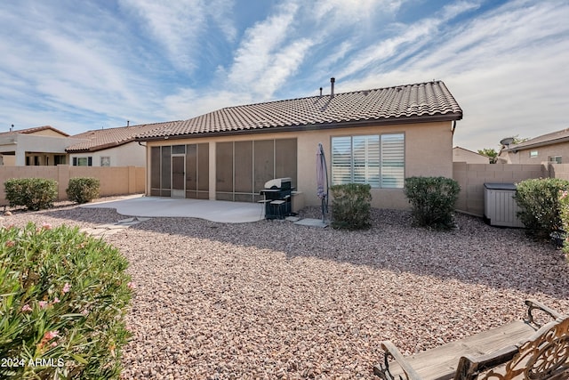 rear view of house with a sunroom and a patio area