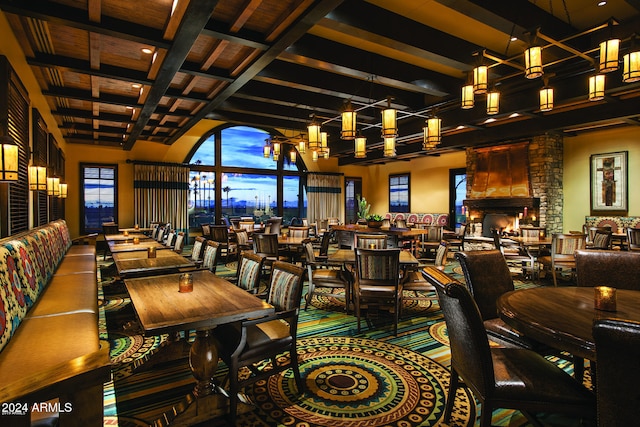 carpeted dining area featuring beam ceiling and a towering ceiling