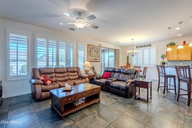 living room with a healthy amount of sunlight and ceiling fan with notable chandelier