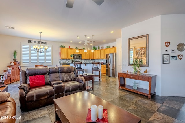 living room with ceiling fan with notable chandelier