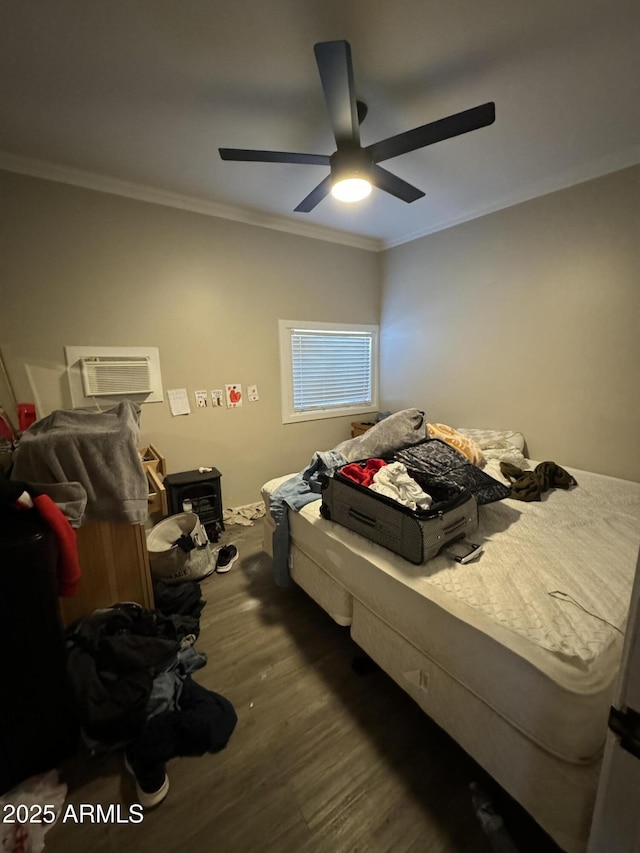 bedroom featuring ornamental molding, dark wood-type flooring, a wall unit AC, and a ceiling fan