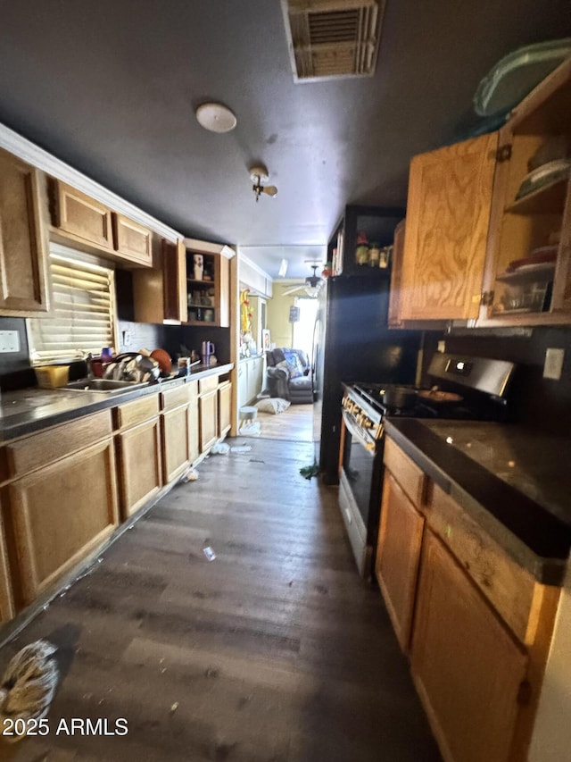 kitchen with dark countertops, visible vents, stainless steel gas range oven, and open shelves