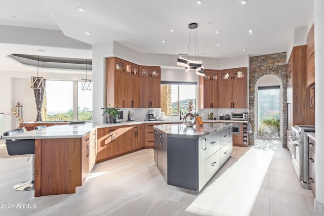 kitchen featuring pendant lighting, high end stainless steel range oven, light tile patterned floors, and a kitchen island