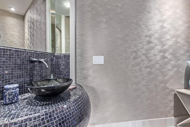 bathroom featuring tile walls and sink