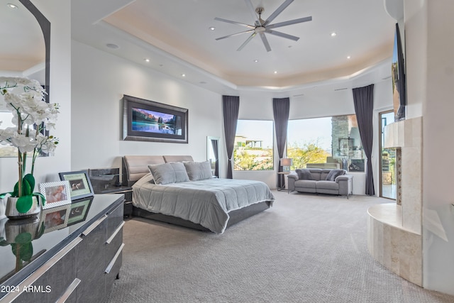 bedroom featuring carpet floors, a raised ceiling, and ceiling fan