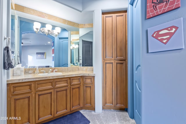 bathroom featuring ceiling fan with notable chandelier and vanity