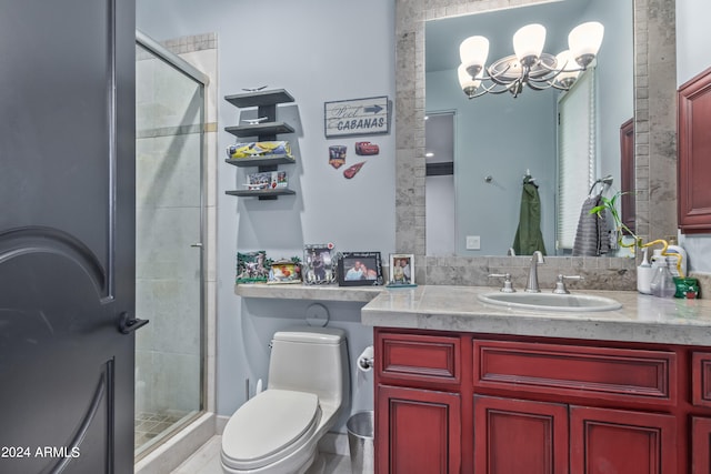 bathroom with an inviting chandelier, vanity, toilet, and an enclosed shower