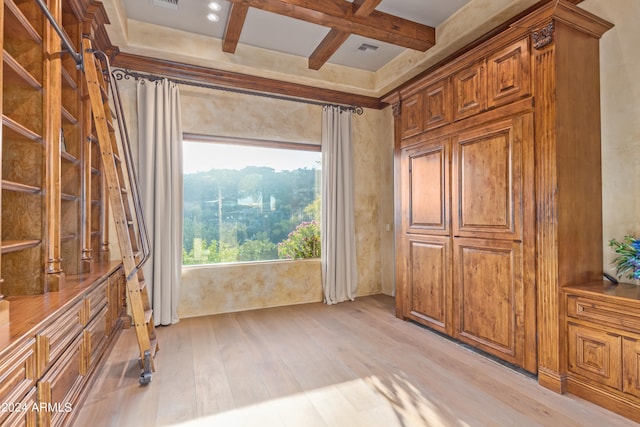 interior space featuring coffered ceiling, beamed ceiling, and light hardwood / wood-style flooring