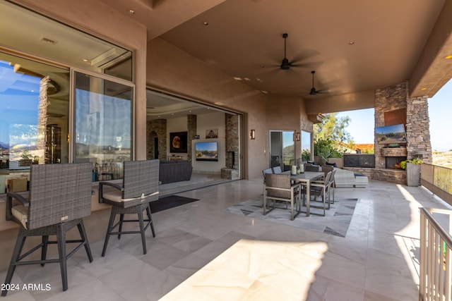 view of patio / terrace with ceiling fan and an outdoor stone fireplace