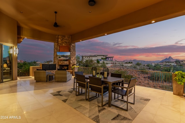 patio terrace at dusk featuring a balcony and ceiling fan