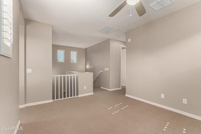 carpeted spare room with ceiling fan