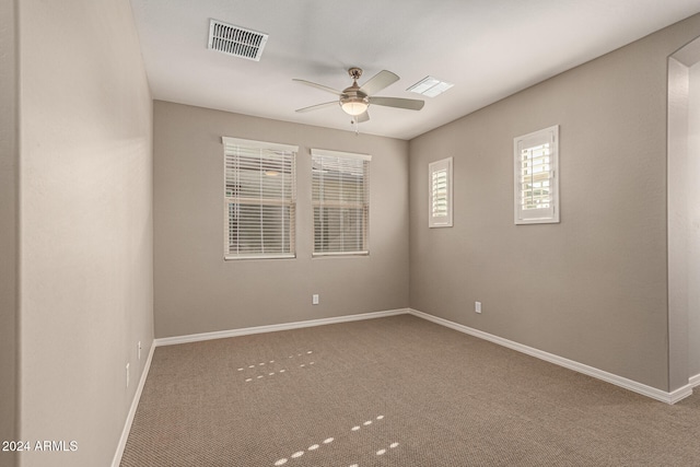 carpeted spare room with ceiling fan