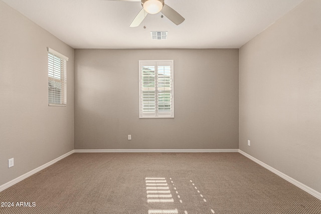 carpeted spare room featuring ceiling fan