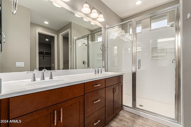 bathroom featuring vanity and a shower with door