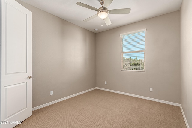 spare room featuring ceiling fan and light colored carpet