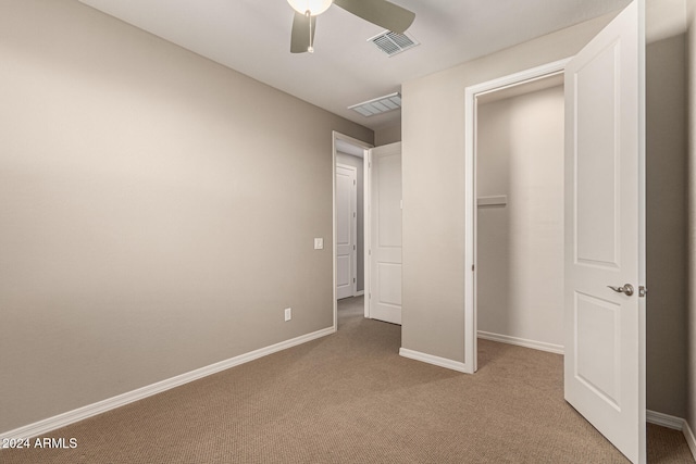 unfurnished bedroom featuring carpet flooring, ceiling fan, and a closet