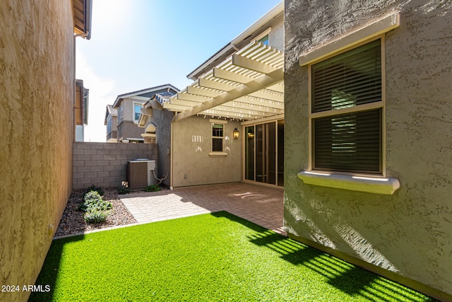 view of yard featuring central AC unit, a pergola, and a patio