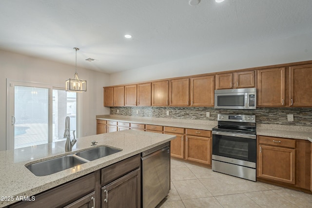 kitchen with stainless steel appliances, sink, light stone counters, decorative backsplash, and pendant lighting