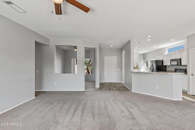 unfurnished living room with light carpet and ceiling fan